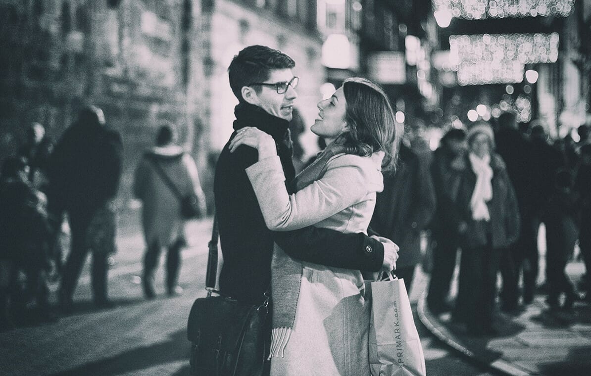 Black and White Photo of a couple (Male and Female) dancing at the Christmas Markets - Taken on a Welshot Street Photography at the Manchester Christmas Markets workshop