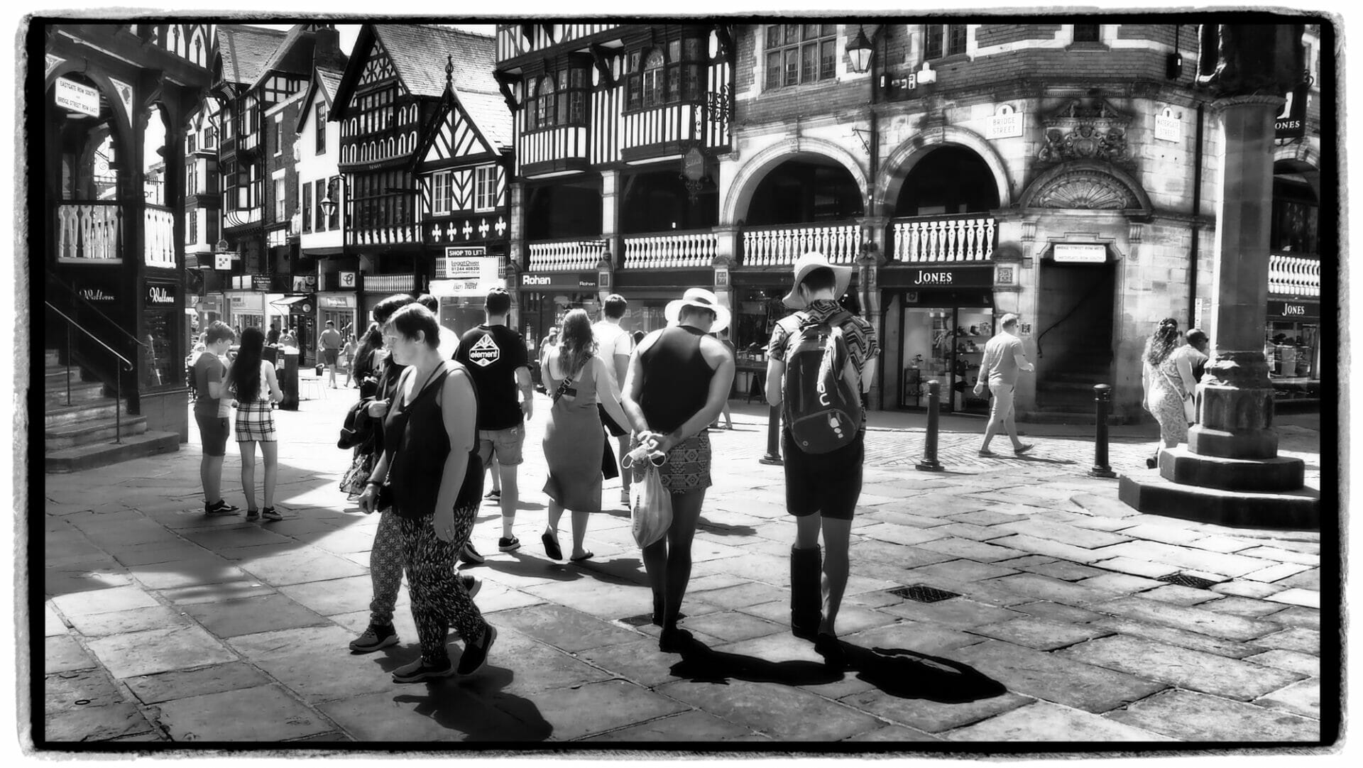 Black and White Photo of a group of people in the streets of Chester. The photos was taken on the Chester Walls - A Photographic Adventure with Welshot