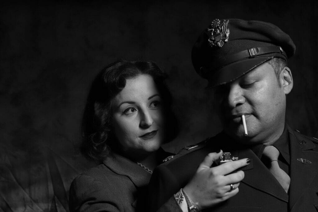 Themed Photo-Shoot:  Film Noir Photography with Welshot - Black and White Photo of Woman holding a cigarette lighter up to a man in uniform 