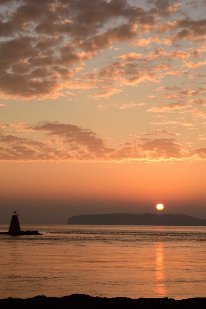 Sunset to Sunrise on Anglesey - Colour photo of the sun rising over the Great Orme, Llandudno from Penmon Point on Anglesey